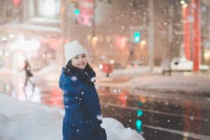 girl standing in snow at christmas