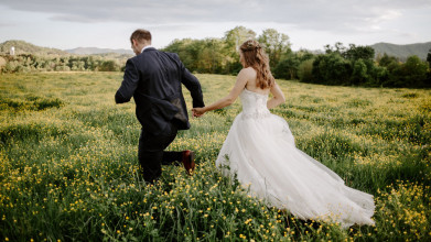 Newly married couple running into field together