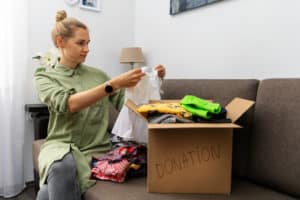 woman sorts clothing donations