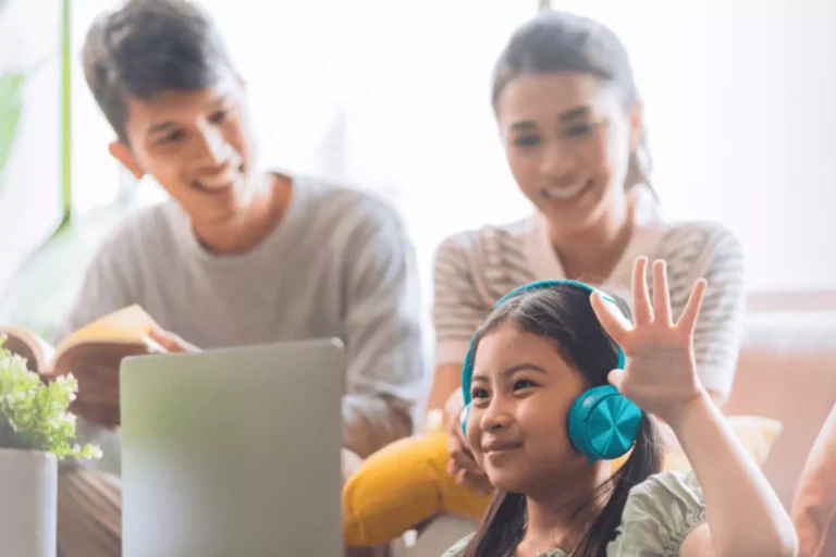 A smiling child with headphones with her parents