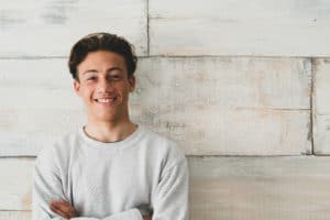 young man standing against wall aging out of foster care