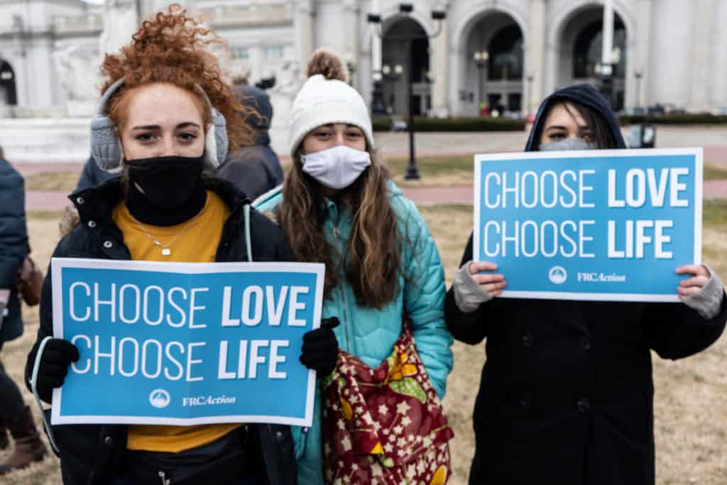 Members of the pro-life generation hold signs saying "Choose Love, Choose Life."