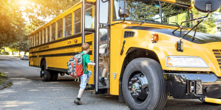 Two children boarding a school bus