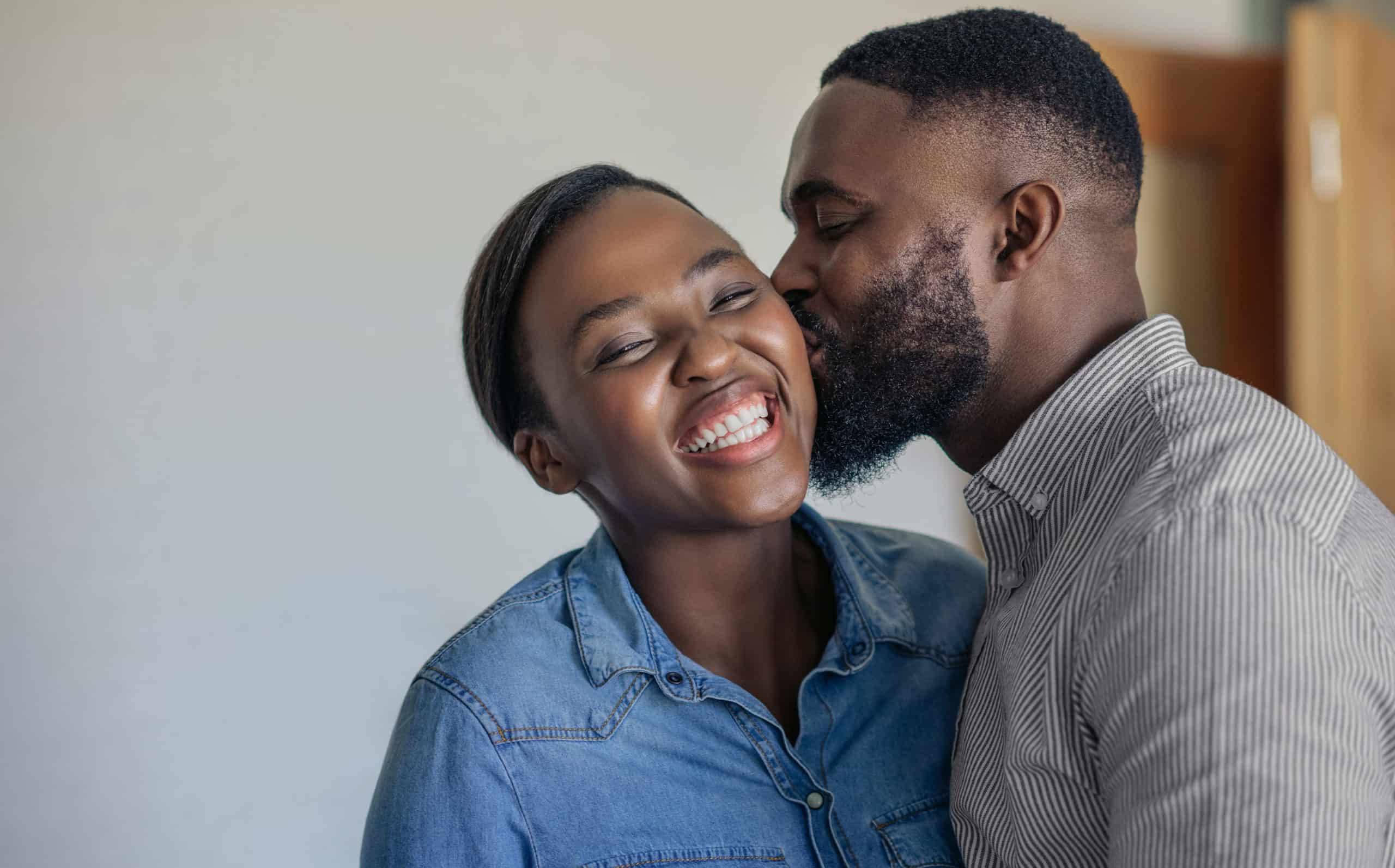 Healthier Habits - Loving African American husband kissing his wife on the cheek