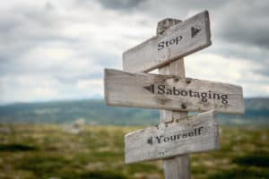 how to deal with control issues in marriage Stop sabotaging yourself text engraved on an old wooden signpost.