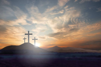 Photo of three crosses at Calvary, backlit by the sun.