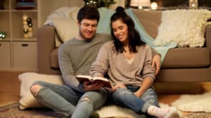 couple-making-personal-time-for-god-after-marriage-reading-Bible-while-sitting-on-the-living-room-floor