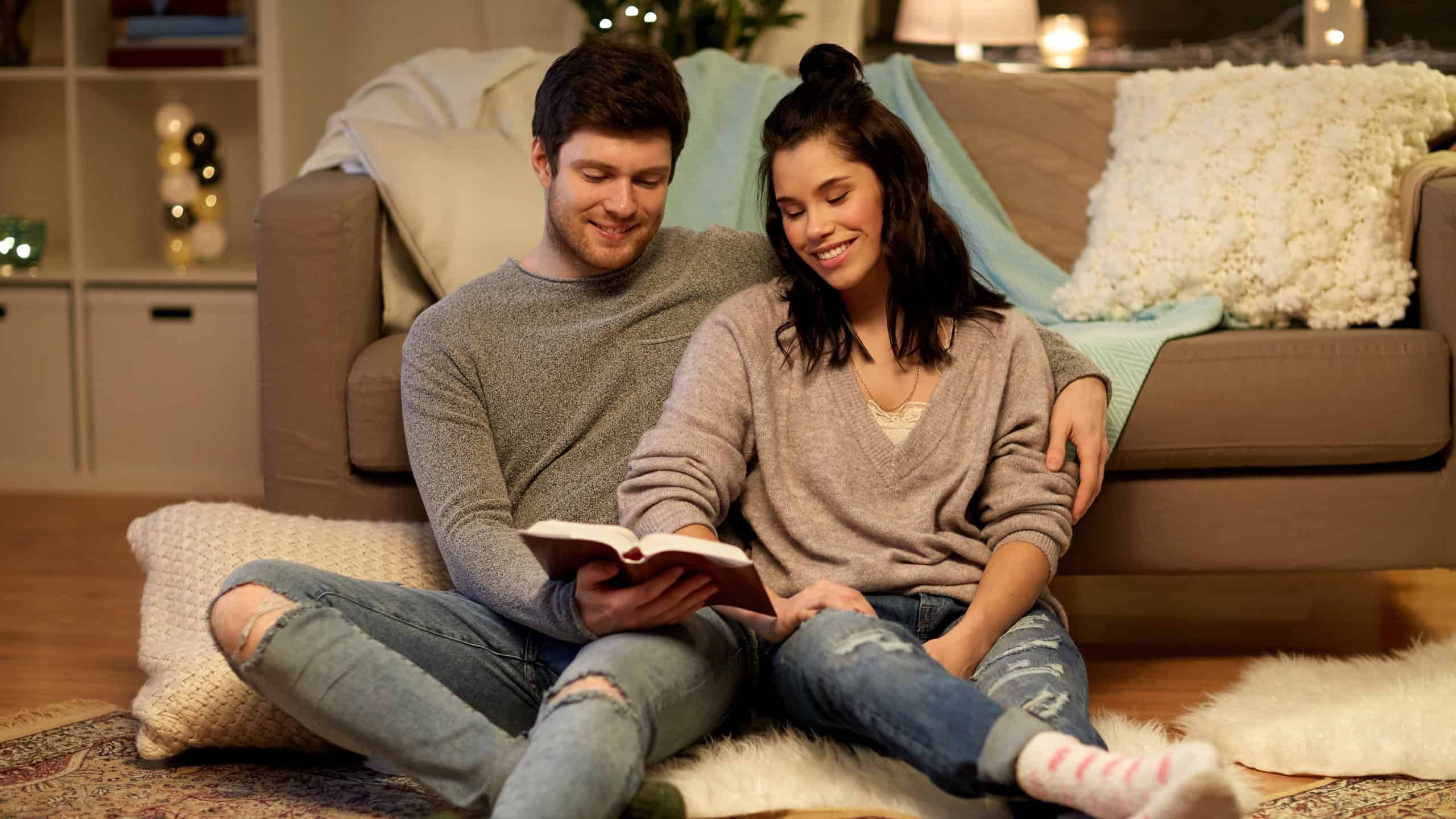 couple-making-personal-time-for-god-after-marriage-reading-Bible-while-sitting-on-the-living-room-floor