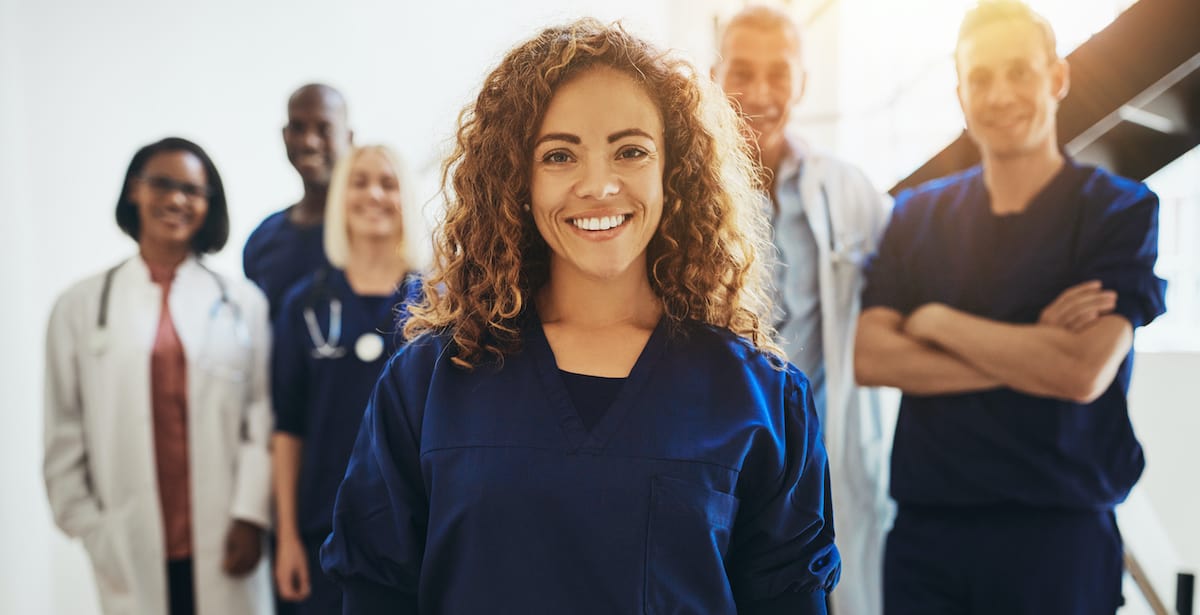 Woman standing in front of medical professionals supporting her pro-life medical clinic