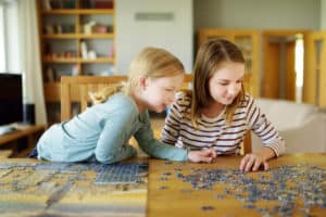 young girls playing puzzles at table