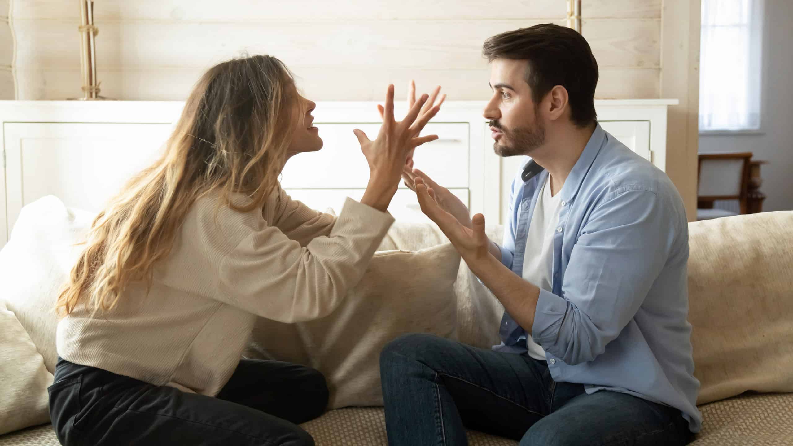 Young couple arguing on a couch about annoying habits