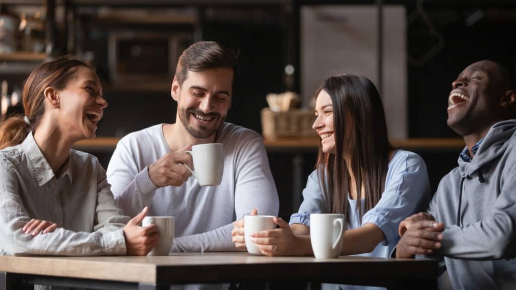 Two young couples having coffee together