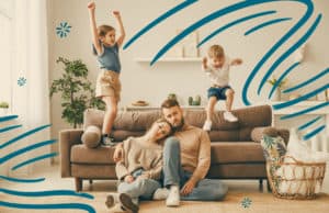 Stressed parents with kids jumping on couch behind them