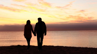 Husband and wife silhouette walking by lake