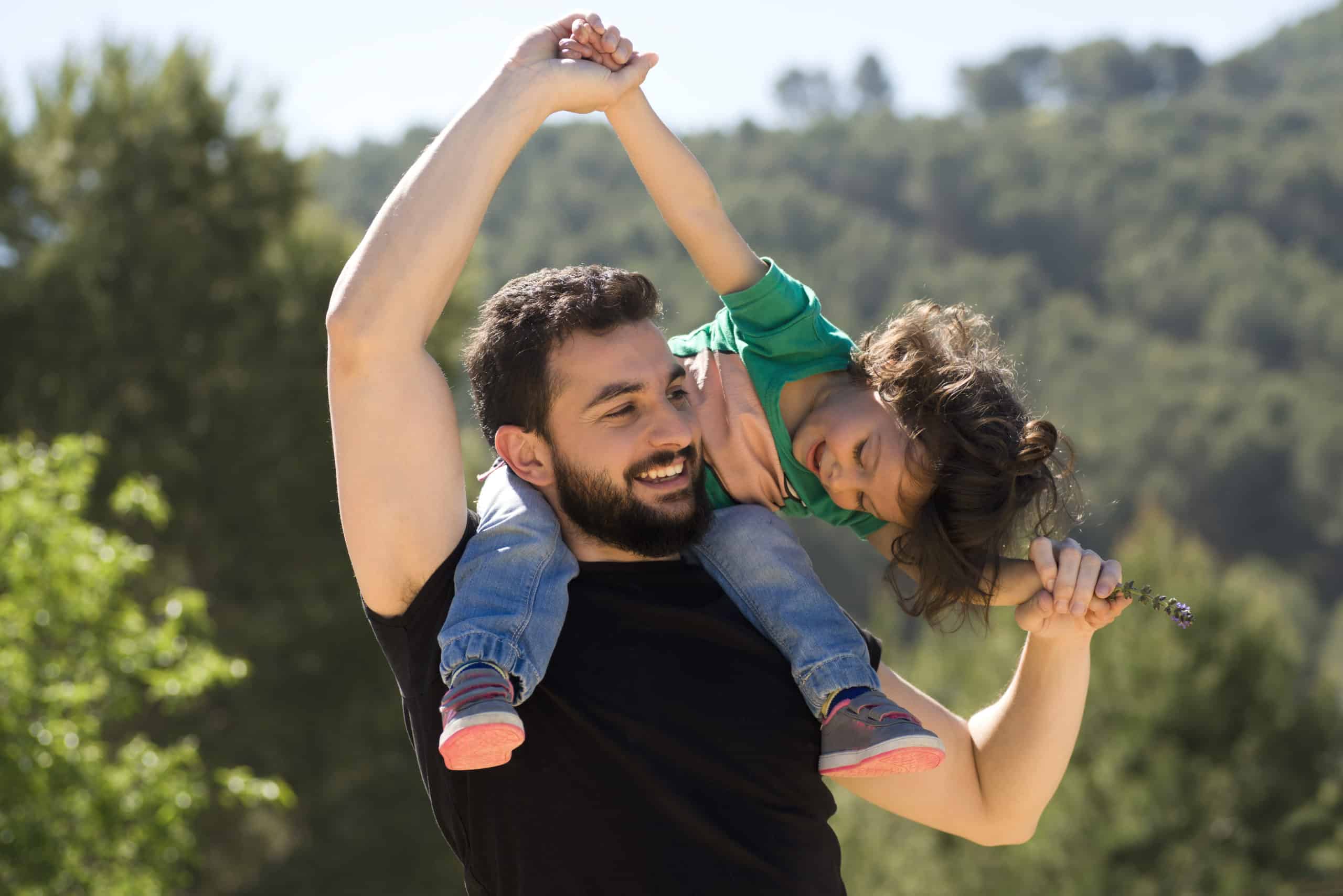 Father with his adopted daughter on his shoulders