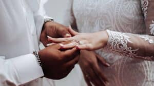 A man puts a ring on the finger of his new bride. Going from partners living together to a married couple has given them trust, strength and hope in their relationship.