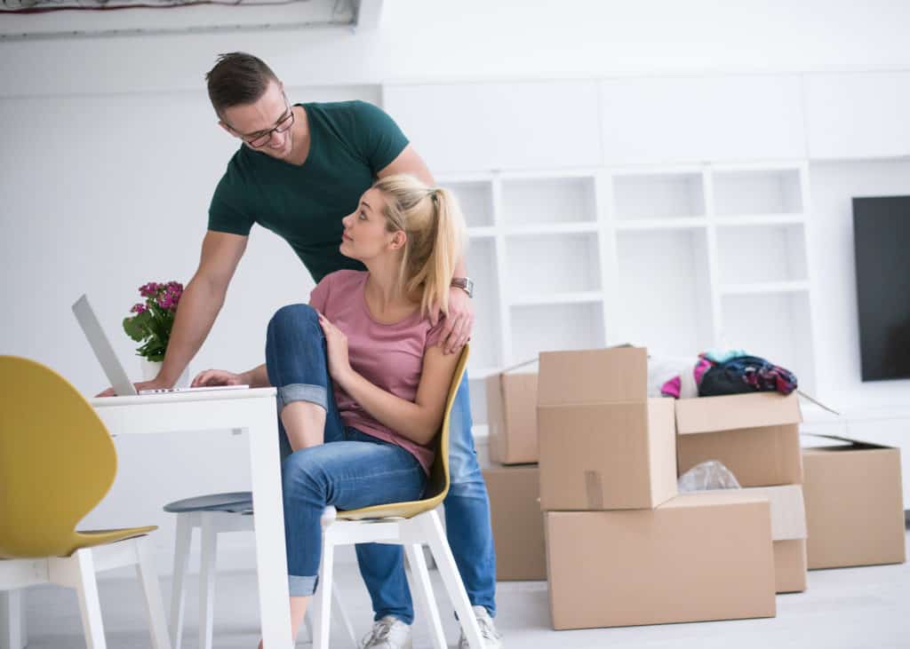 Photo-young-couple-moving-into-home-with-boxes-around-them