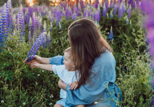 Mom holding young son in field of purple flowers