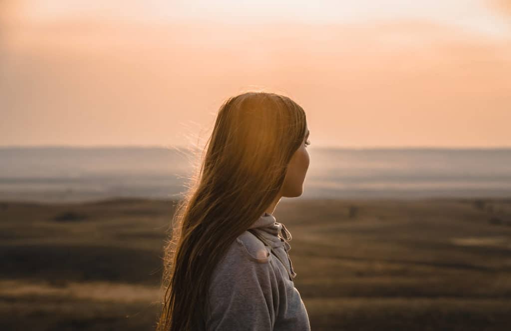 A woman looking out as she thinks about abortion complications