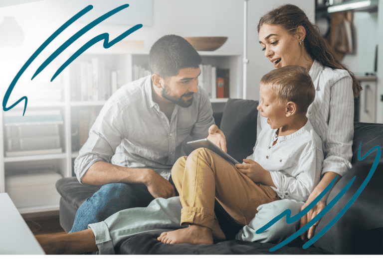 Young boy holding a tablet in his lap, sitting on a couch together with his mom and dad as they explain something to him