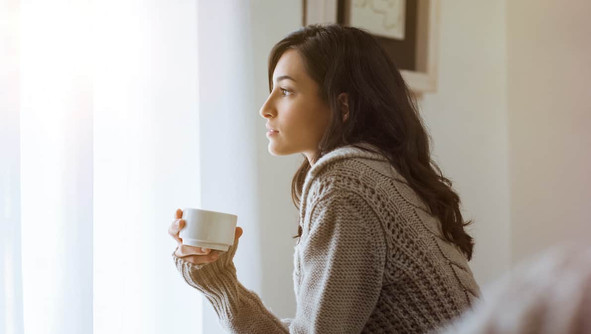 A woman sits looking out her window contemplating the true cost of abortion