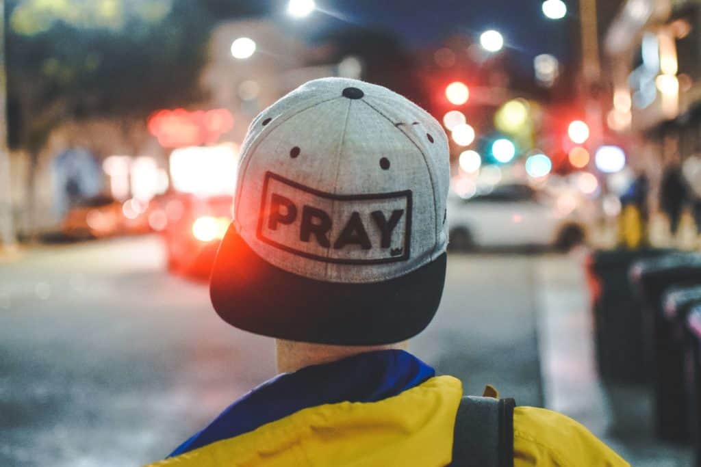 Man wearing a hat that says pray to encourage others in a father's prayer