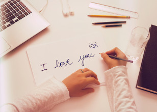 hands-writing-a-love-letter-on-paper