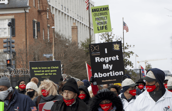 A marcher at the march for life holds a sign saying "I regret my abortion."