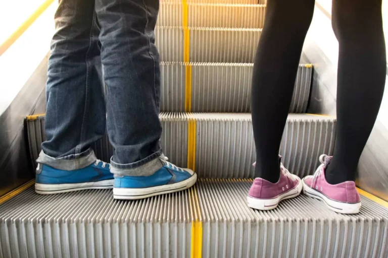 A close-up of two people standing on an escalator, symbolizing the need to stop fighting by stepping off the emotional escalator in relationships.