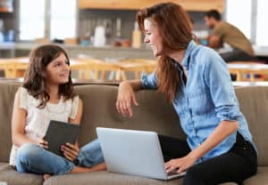 Mother sitting with her daughter on a couch/