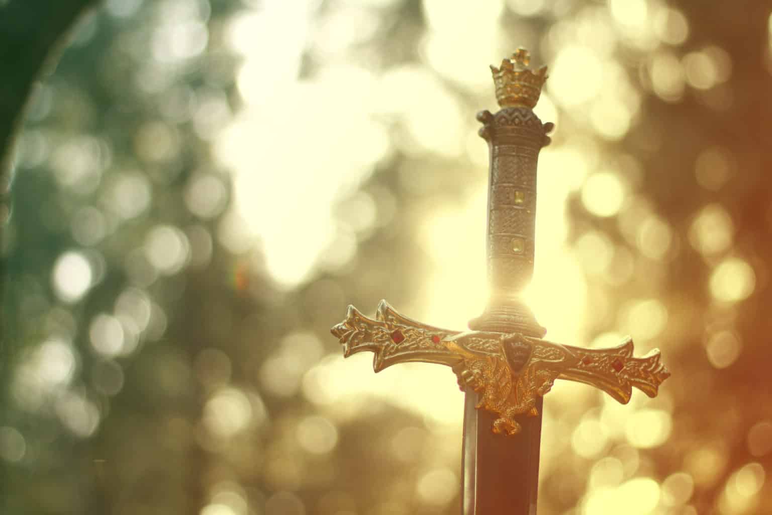 Close-up of the hilt of a king's sword against a glowing, sparkling background