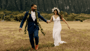 Newlywed couple walking in a field.