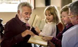 Photo of an elder church leader talking to kids