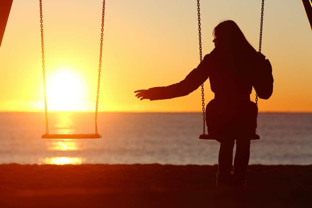 Woman reaching out to empty swing needing words of comfort after a miscarriage