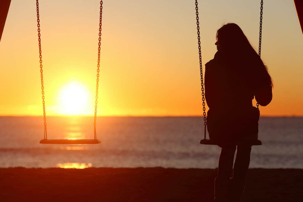 Woman alone on swing thinking what not to say to someone who lost a child
