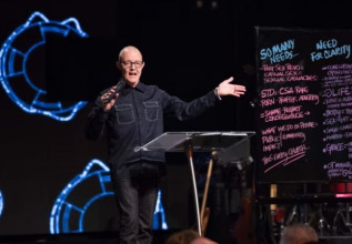 Photo of Pastor Sy Rogers speaking on stage