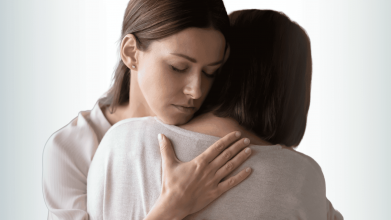 mother helping her daughter with overcoming anxiety and depression as the girl is covering her face crying