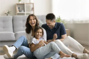 Family of three laughing together in the living room