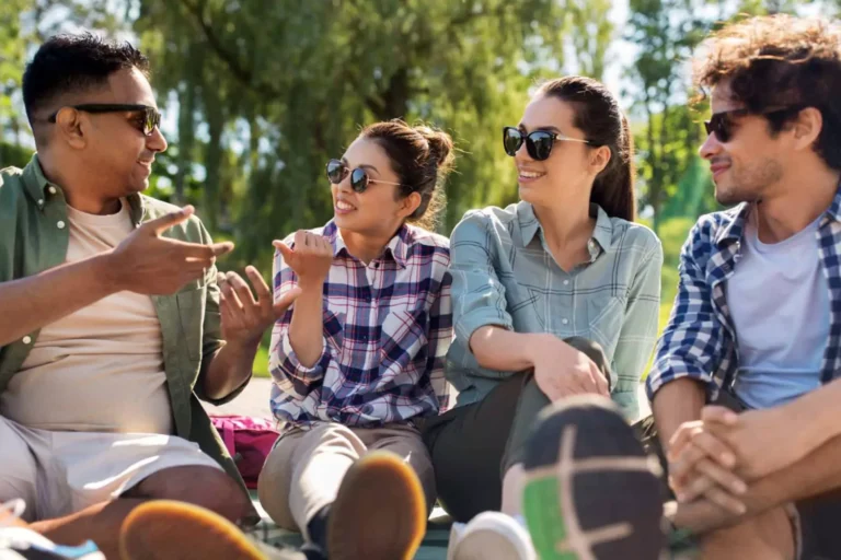 A group of friends sits outdoors, laughing and chatting, representing how a perfectly imperfect marriage can inspire and bless others through shared experiences.