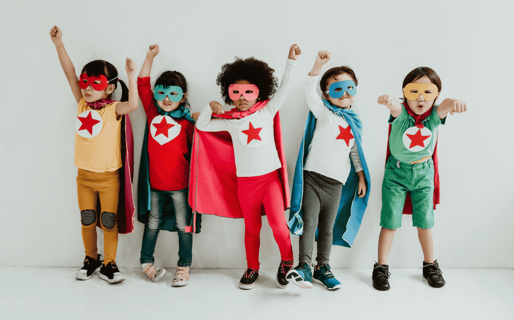 Group of children playing superhero on the white wall background