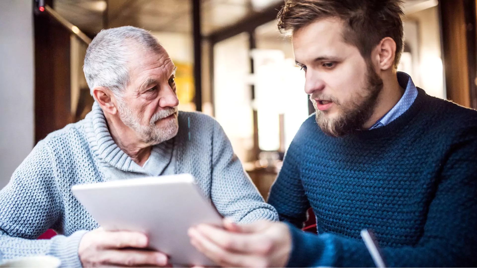 A father sits with his future son-in-law and asks him 12 questions, written on the piece of paper he holds between them.