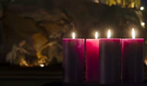 Advent Candles burning with Nativity in the background.