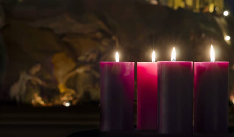 Advent Candles burning with Nativity in the background.