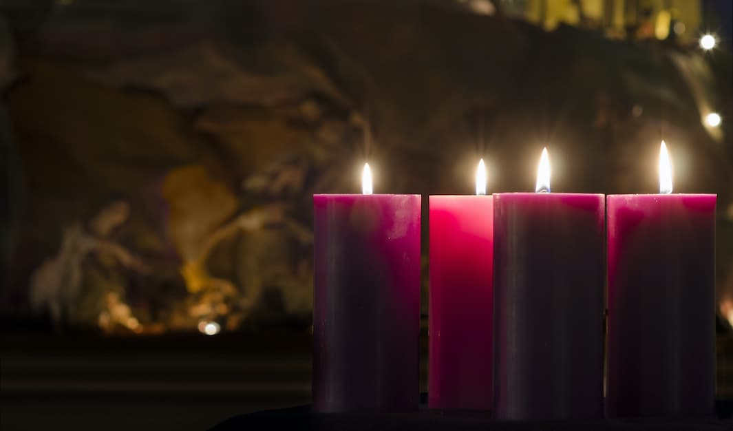 Advent Candles burning with Nativity in the background.