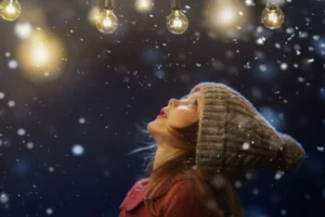 Child looking up at Christmas lights and stars