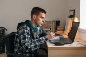 Young man from group home works on college work