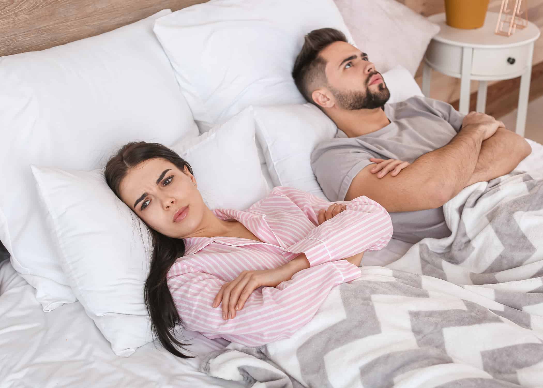 Unhappy-young-couple-turned-from-each-other-in-bed