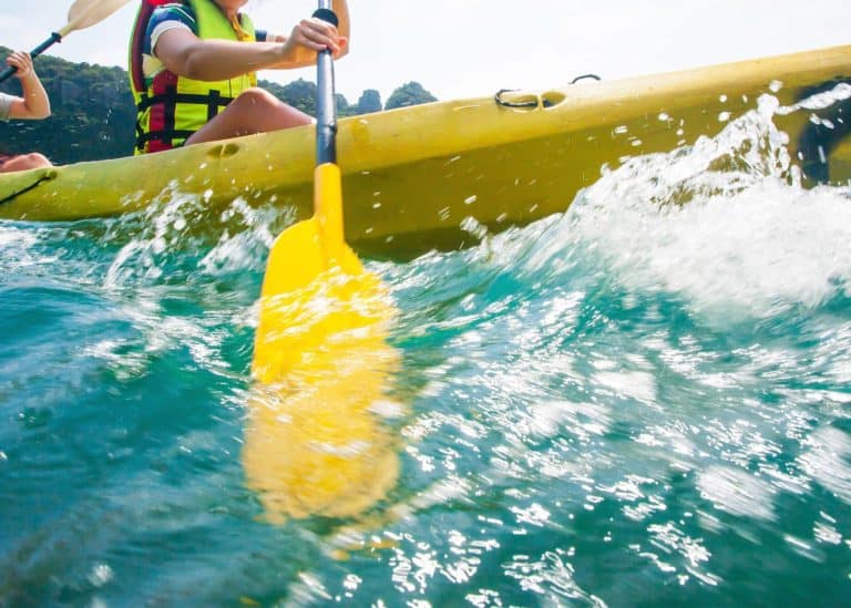 Couple-paddling-hard-in-a-kayak-with-churning water