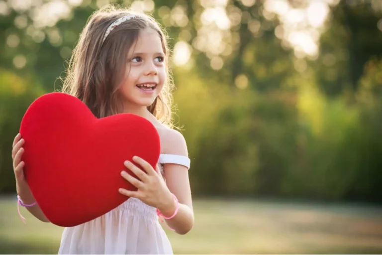 little girl holding a big red heart for valentines day activities