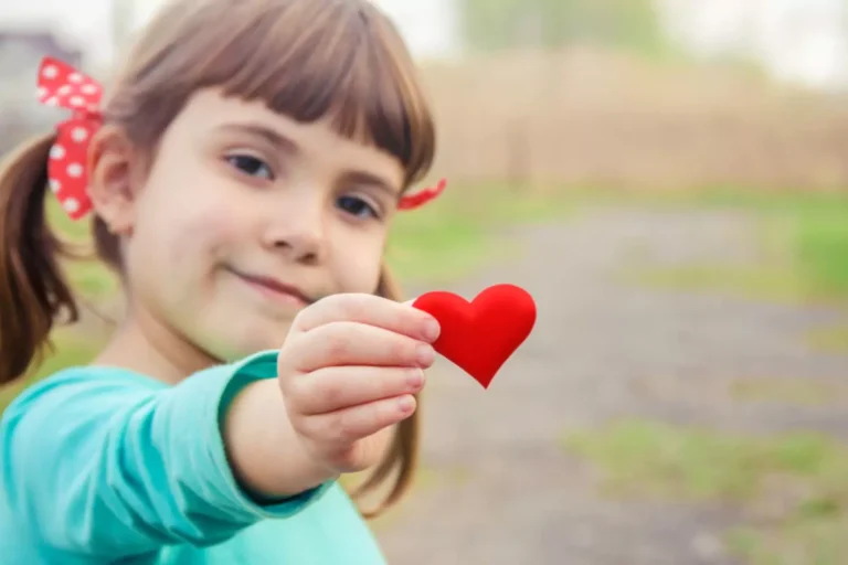 parents guide for valentines day. Little girl with pigtails holding a paper heart